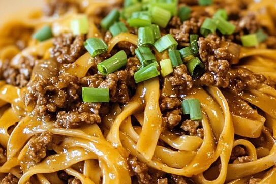 Delicious **Authentic Chinese Food Near Me in NY – savor flavorful, stir-fried noodles topped with savory minced meat and fresh green onions. A must-try dish for Chinese cuisine lovers!